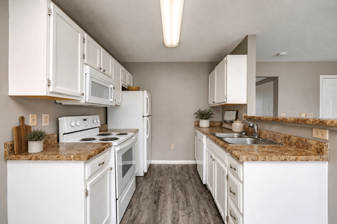 A kitchen with white appliances and cabinets.