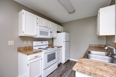 A kitchen with white appliances and cabinets.