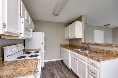 A kitchen with white appliances and cabinets.