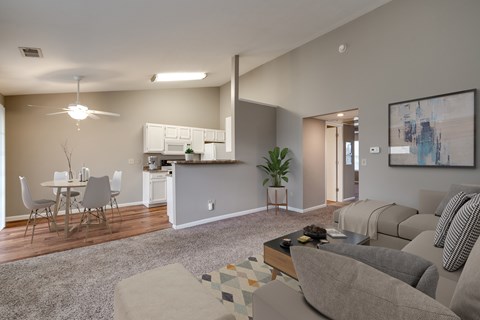 A modern living room with a kitchen area in the background.