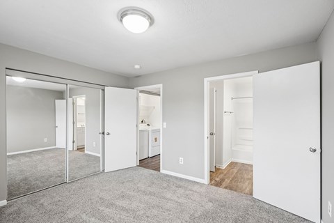 A spacious room with a grey carpet and white walls.
