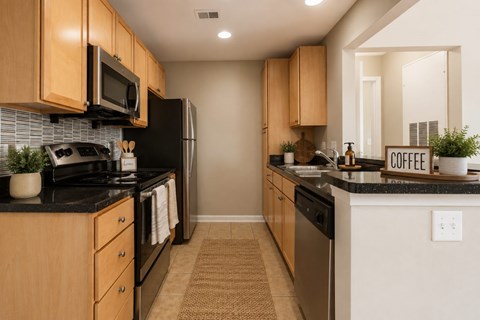 A kitchen with wooden cabinets and black appliances.