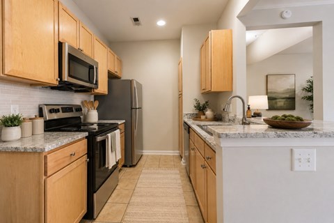 A kitchen with wooden cabinets and black appliances.
