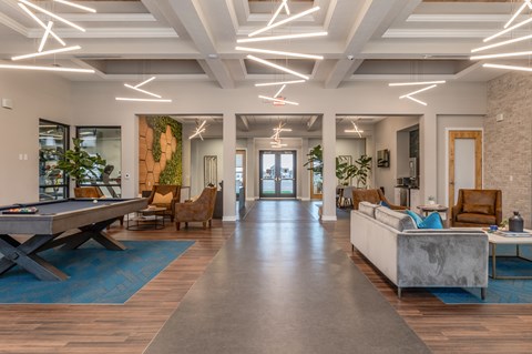 A spacious living room with a pool table and comfortable seating.