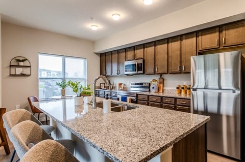 A kitchen with a granite countertop and stainless steel appliances.