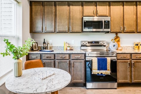 A kitchen with a marble table and a stove with a towel on it.