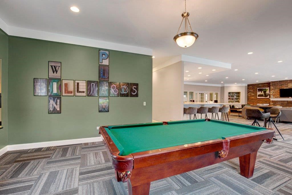 a pool table in a game room with a bar
