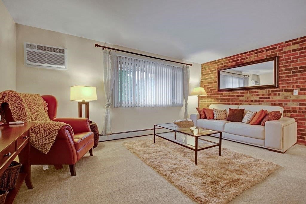 a living room with a white couch and a brick wall