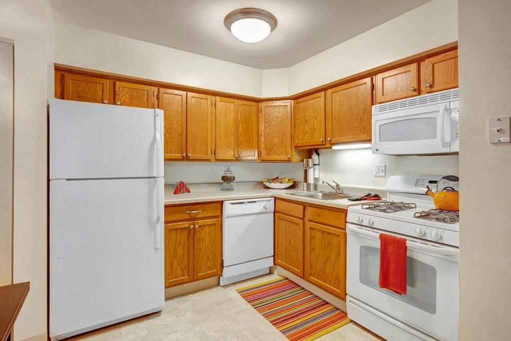 a kitchen with white appliances and wooden cabinets