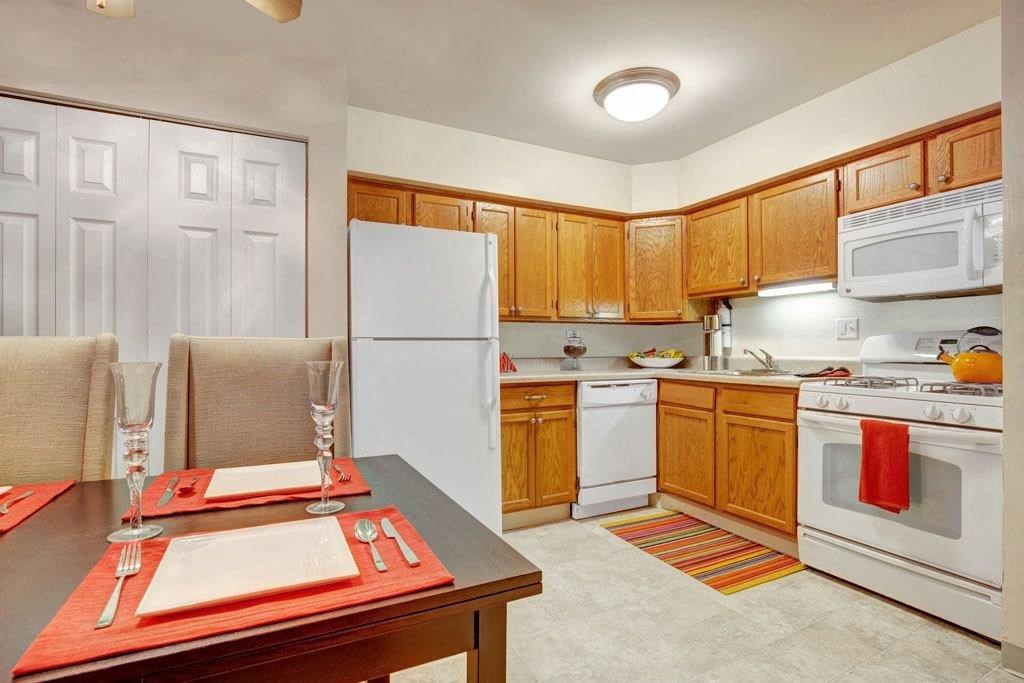 a kitchen with a table and a white refrigerator