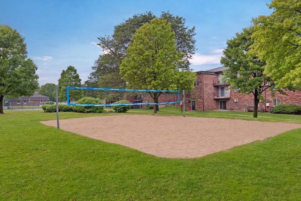 a volleyball court in a park in front of a brick building