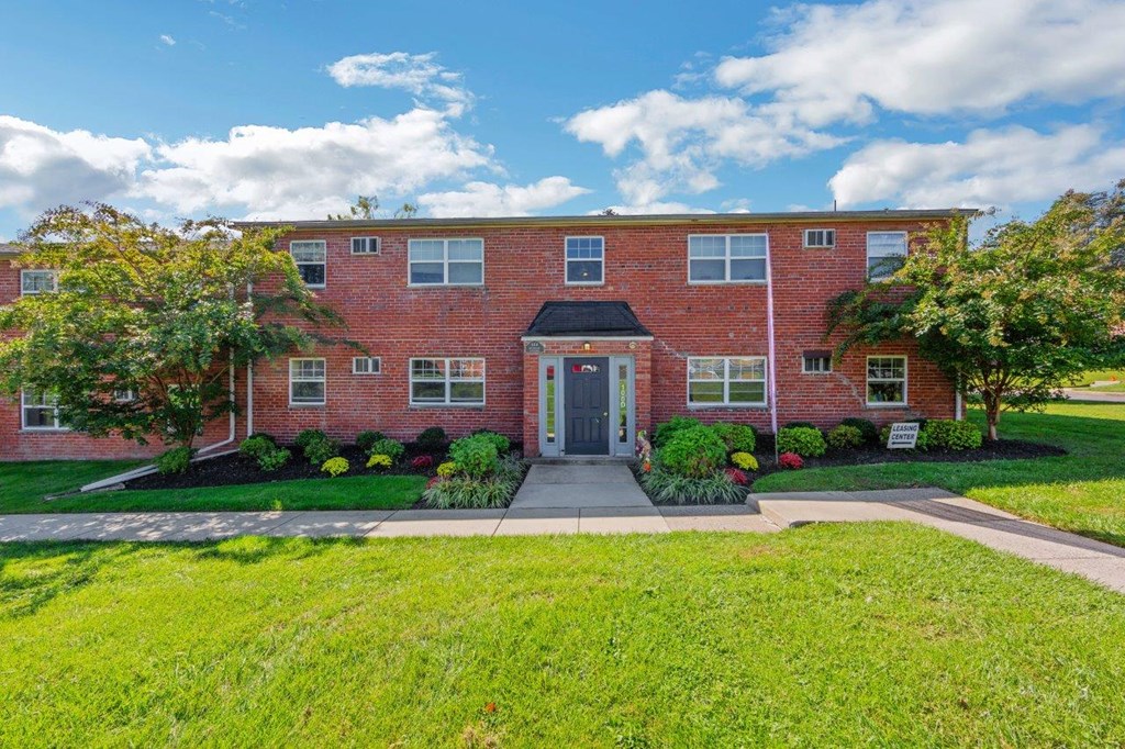 a red brick house with a sidewalk in front of it