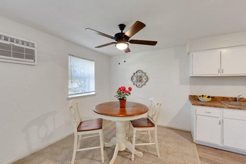 A dining room with a table and chairs.