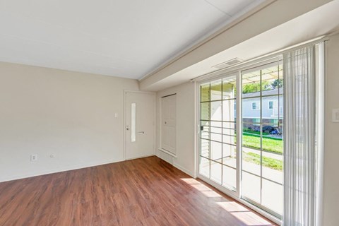 a living room with wood floors and a large window