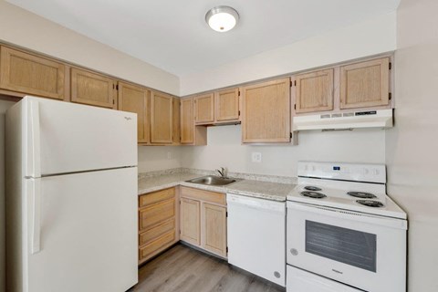 a kitchen with white appliances and wooden cabinets