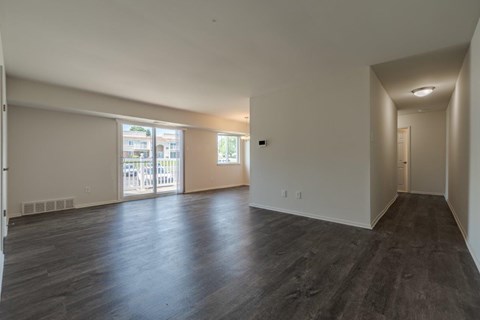 A spacious room with wooden floors and white walls.