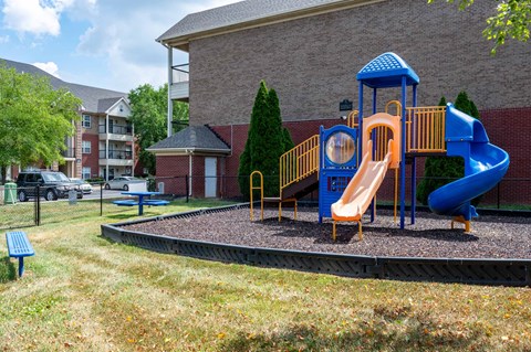 A playground with a blue slide and yellow structure.