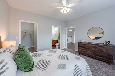 A bedroom with a bed, dresser, and mirror.