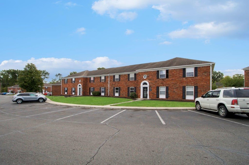 a large brick building with cars in a parking lot