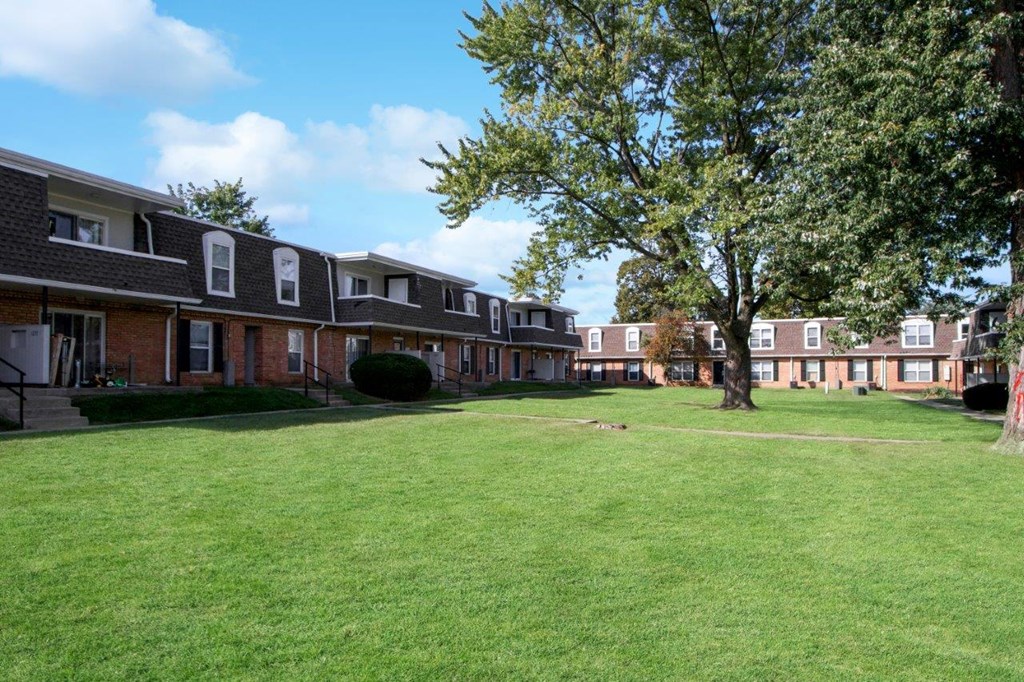 a green lawn in front of a row of houses