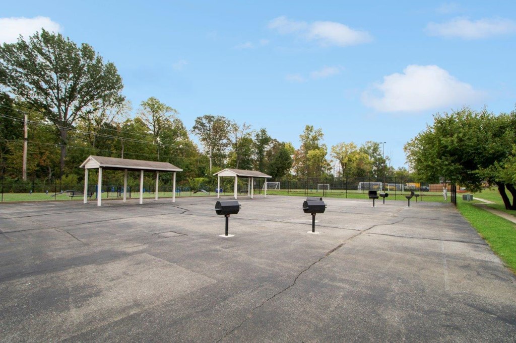 the parking lot at the park has benches and trash cans