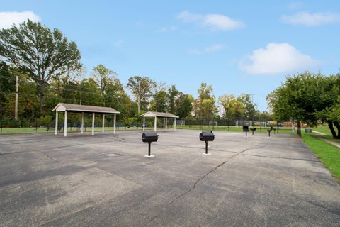 the parking lot at the park has benches and trash cans