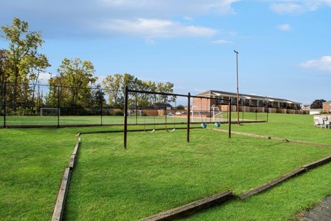 a park with a soccer field and a chain link fence