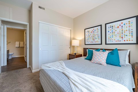 A bedroom with a large bed and two framed pictures on the wall.