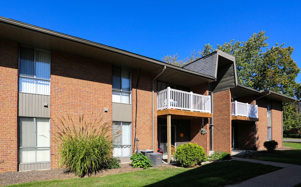 A red brick building with a balcony on the second floor.