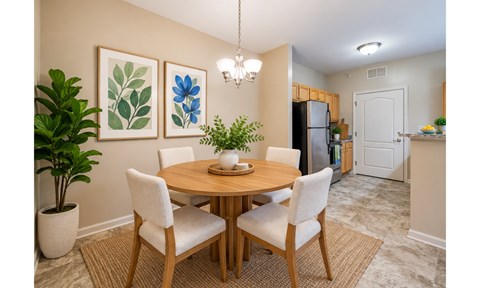 A dining room with a round table and chairs.