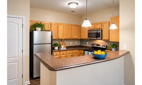 A kitchen with wooden cabinets and a granite countertop.