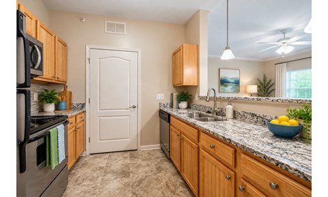 A kitchen with wooden cabinets and granite countertops.