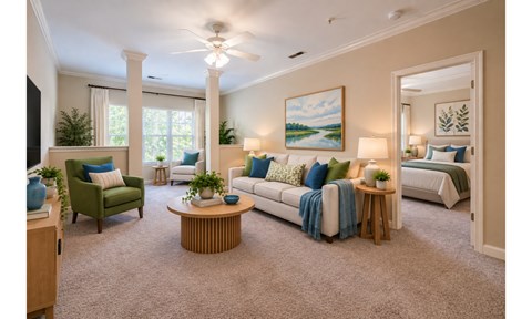 A living room with a green chair, a white couch, and a painting on the wall.