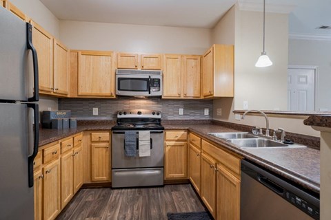 A kitchen with wooden cabinets and a stainless steel refrigerator.