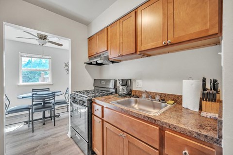 A kitchen with wooden cabinets and a granite countertop.