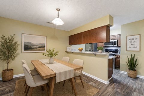 A dining room with a wooden table and chairs.