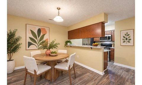 A dining room with a table and chairs.