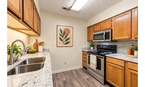 A kitchen with wooden cabinets and a stainless steel oven.