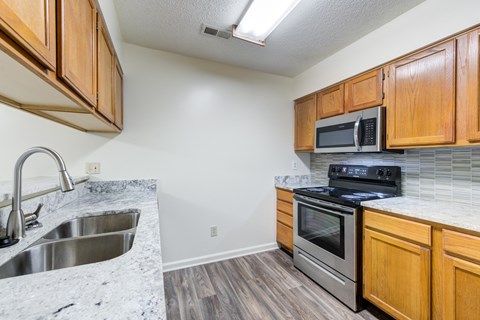 A kitchen with wooden cabinets and a black stove top oven.