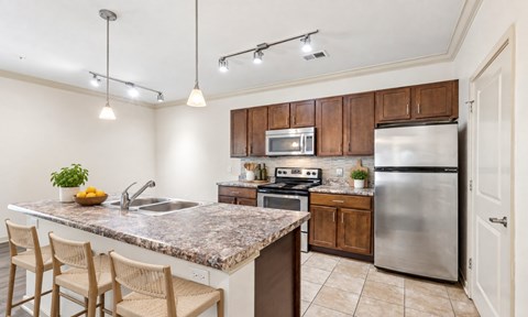 A kitchen with a granite countertop and stainless steel appliances.