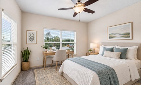 A bedroom with a bed, desk, and chair.
