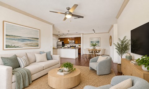 A living room with a couch, chairs, and a ceiling fan.