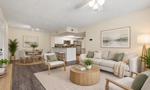 A living room with a white couch, a coffee table, and a painting on the wall.