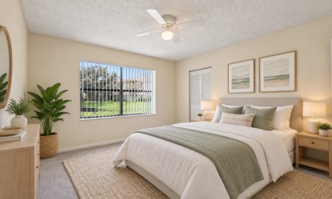 A bedroom with a large bed and a ceiling fan.