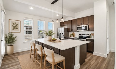 A kitchen with a white countertop and brown chairs.