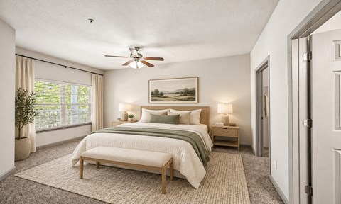 A bedroom with a large bed and a ceiling fan.