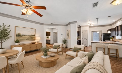 A living room with a ceiling fan and a painting on the wall.