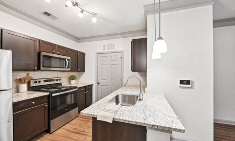 A kitchen with a white counter top and brown cabinets.
