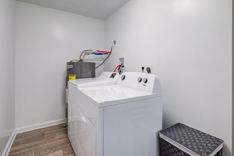 A white washing machine in a small room with a grey floor.