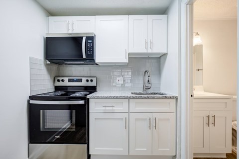 A kitchen with black and white appliances and cabinets.